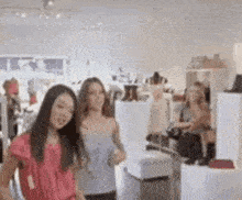 two women are standing in a store looking at clothes