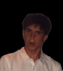 a man in a white shirt looks at the camera with a black background