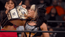 a female wrestler is holding a us heavyweight championship belt