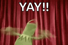 kermit the frog is dancing in front of a red curtain with the words `` yay ! ''
