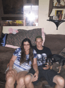 a man wearing a shirt with skulls on it sits next to a woman