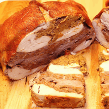 a large piece of meat is sitting on top of a wooden cutting board