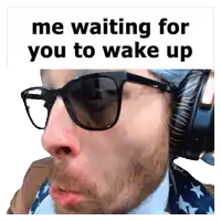 a man wearing sunglasses and headphones with the words me waiting for you to wake up above him