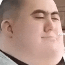 a close up of a fat man with his eyes closed .