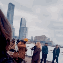 a group of people standing on a bridge in front of a city skyline with a sign that says ' a ' on it