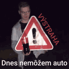 a man holding a coca cola bottle in front of a triangle sign that says vystraha