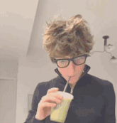 a person wearing glasses is drinking from a cup that says juice