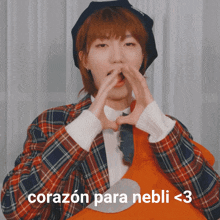 a person making a heart shape with their hands and the words corazon para nebli < 3