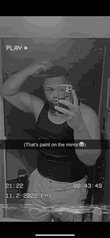 a black and white photo of a man taking a selfie with a caption that says " that 's paint on the mirror "