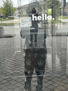 a person is standing in front of a glass door that says hello on it