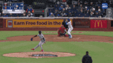 a baseball game is being played in front of an earn free food in the mcdonald 's sign