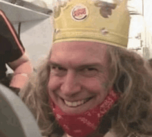 a man is wearing a burger king crown and a red bandana .