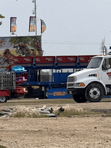 a white truck is parked in front of a carnival ride that says wonder wheels