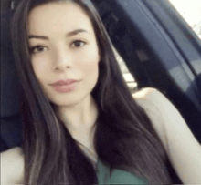 a woman is taking a selfie in a car .