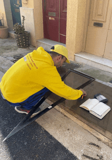 a man wearing a yellow hoodie that says " cleaning malta " on the back