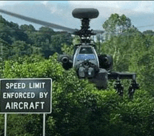 a helicopter is flying in front of a speed limit sign