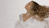 a woman in a white dress with feathers and rhinestones