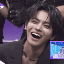 a close up of a man 's face with a purple box in the background that says ' a ' on it
