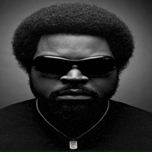 a man with a beard wearing sunglasses and a dog tag necklace
