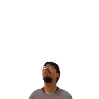 a man with glasses and a beard is looking up at a green cross on his head