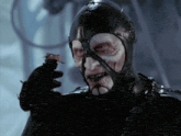 a man in a black mask is holding a small object