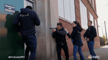 a group of police officers are standing in front of a building with a sign that says emergency for only do not block