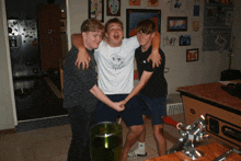 three young men are posing for a picture with one wearing a white shirt that says ' i love you ' on it