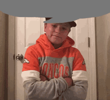 a boy wearing an orange and gray denver broncos sweatshirt