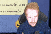 a man sitting in front of a sign that says " se enviar an al hq "
