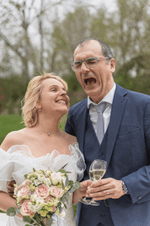 a bride and groom making a funny face while holding glasses of champagne