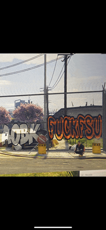 a fence with graffiti on it including the word fucksu