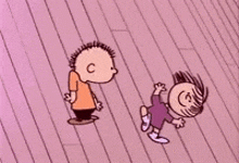 a boy and a girl are standing on a pink wooden floor .