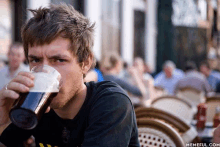 a man drinking from a glass with a memeful.com watermark