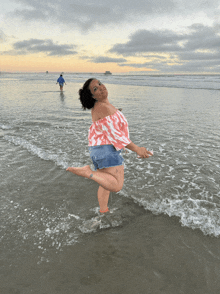 a woman stands on one leg in the ocean