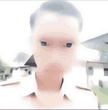 a blurry picture of a man 's face with a white shirt on .