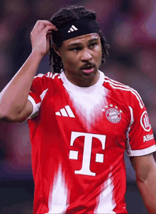 a soccer player wearing a headband with the letter t on the front