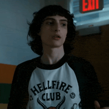 a young man wearing a black and white shirt that says hellfire club