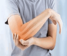 a man is holding his elbow in pain because of a muscle strain .