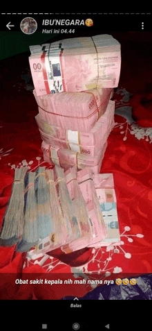 a bunch of money stacked on top of each other on a bed with a caption that says ibu negara