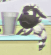 a sheep is sitting on a table next to a glass of water