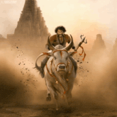 a man is riding on the back of a bull with a x on the bottom right