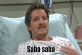 a man laying in a hospital bed with saba saba written on his chest