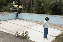 a man wearing a helmet stands in front of a swimming pool