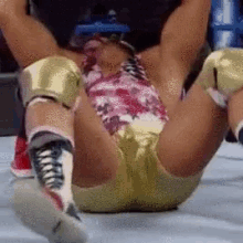 a wrestler is laying on the floor with a bloody shirt on