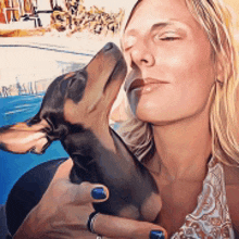 a woman is holding a small dog in her arms and the dog is sniffing her face