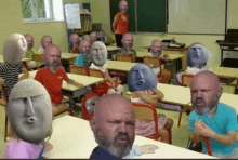 a group of bald men with faces on their heads are sitting at tables in a classroom with a teacher .