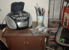 a sony radio sits on a wooden table next to a stack of cds