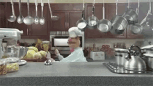 a puppet in a chef 's hat is cooking in a kitchen .