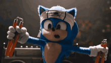 sonic the hedgehog is wearing a karate headband and holding a pair of nunchucks