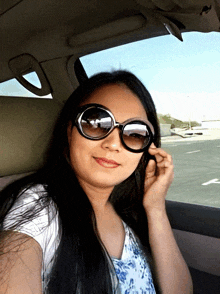 a woman wearing sunglasses sitting in a car